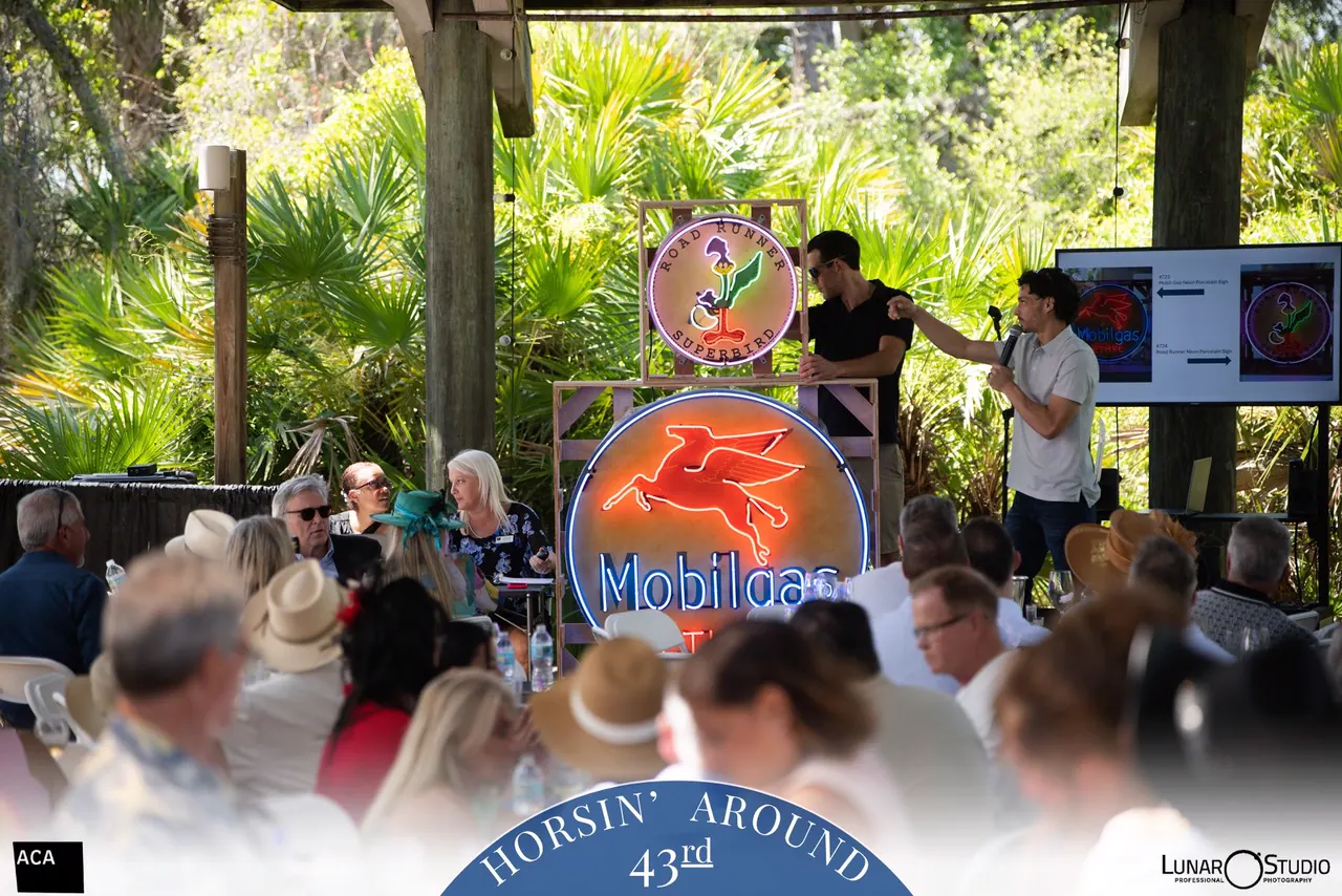 Darrien Eouse presenting advertising signs at the 2026 Horsin’ Around benefit auction